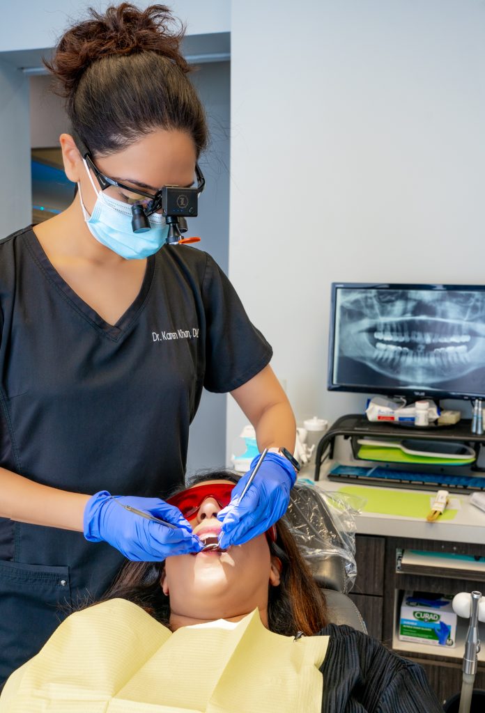 Dr.Karen Khan providing dental care to a Sweet Tooth Smiles patient in Richmond and Memorial, Texas.